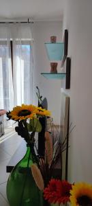 un vaso verde con fiori in una stanza di Serena GuestHouse a Monopoli