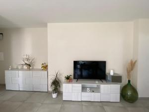 a living room with a television on a white cabinet at Casa Martina in Cuneo