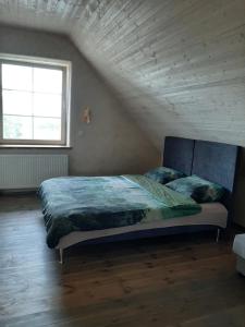 a bedroom with a large bed in a attic at Vila Sanzila in Bernatoniai