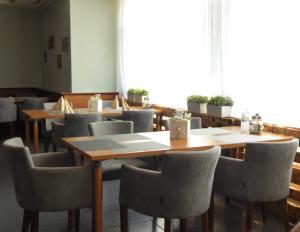 a dining room with wooden tables and chairs at Atrium Gästezimmer und Restaurant - Hohenau an der March in Hohenau