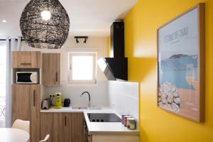 a kitchen with a sink and a yellow wall at ColorPop - Netflix Wifi Tout équipé - Appart Pézenas Centre in Pézenas +22 photos