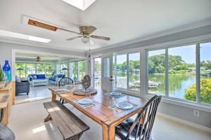 Un comedor con mesa y sillas y ventanas. en Idyllic Waterfront Home with Game Room and Dock, en Reedville