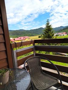 a table and a chair on a balcony with a view at Apartman Ana in Mrkopalj