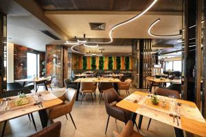 une salle à manger avec des tables et des chaises en bois dans l'établissement Aniroc Signature Hotel, à Arad