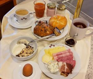 einen Tisch mit Teller mit Speisen und Tassen Kaffee in der Unterkunft Hotel-Café 3 Kronen in Burglengenfeld
