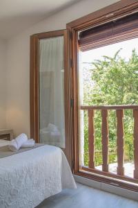 1 dormitorio con ventana y vistas a un árbol en Apartamentos Vista Veleta, en Capileira