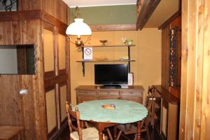 um pequeno quarto com uma mesa e uma televisão em casa Luca Prato Verde 1 em Pescasseroli