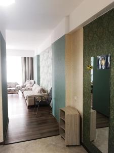 ein Wohnzimmer mit einem Sofa und einem Bett in einem Zimmer in der Unterkunft Apartment Alex II in Kobuleti