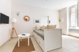 Dormitorio blanco pequeño con cama y mesa en Charmant Appartement en Hypercentre, en Toulouse