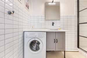 Un baño con lavadora y lavabo. en Charmant Appartement en Hypercentre, en Toulouse 4 fotos más