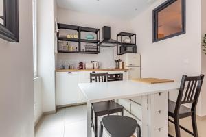 cocina con encimera blanca y sillas en Charmant Appartement en Hypercentre, en Toulouse