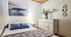 a bedroom with a bed with blue pillows on it at Holiday home Smokvin Hlad in Peroj