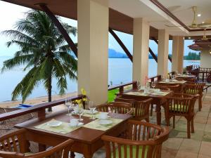 - un restaurant avec des tables et des chaises et une vue sur l'océan dans l'établissement Sara Beachfront Boutique Resort, à Pathiu