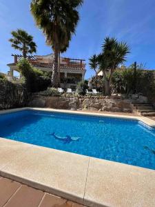 a swimming pool in front of a house with palm trees at Casa con piscina en el centro de Marbella. in Marbella