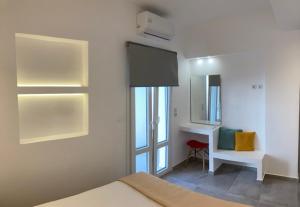 a bedroom with a bed and a desk and a mirror at IosAgnanti in Ios Chora