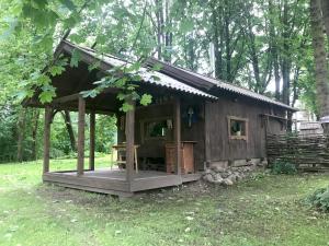 a small wooden house in the middle of a field at Medže dirbtuve 