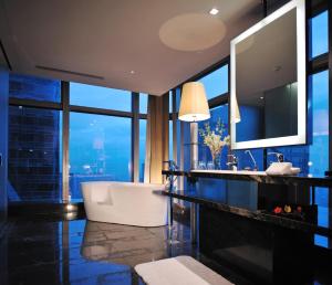 ein Bad mit einer Badewanne und einem großen Fenster in der Unterkunft Wongtee V Hotel in Shenzhen