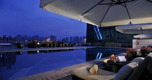 a swimming pool on top of a building with an umbrella at Wongtee V Hotel in Shenzhen