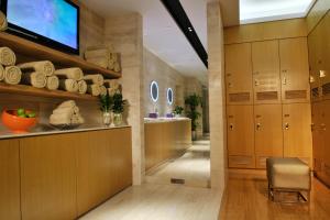 un couloir avec des armoires en bois, une télévision et une chaise dans l'établissement Wongtee V Hotel, à Shenzhen