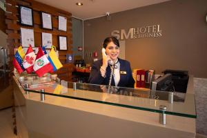 Eine Frau, die am Tresen sitzt und telefoniert. in der Unterkunft SM Hotel in Lima