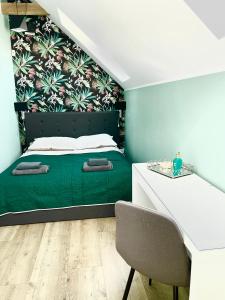 a bedroom with a green bed and a desk at AROMA DĘBKI Całoroczny prywatny dom na zamkniętym osiedlu. in Dębki