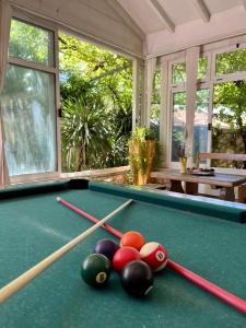 a pool table with balls on it in a room with windows at Gorana apartman with swimming pool in Jelsa