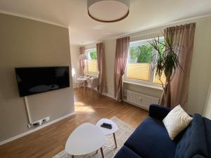 a living room with a blue couch and a tv at Modern Smuuli apartment in Kuressaare