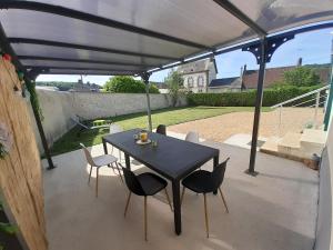un tavolo nero e sedie su un patio di Gîte Les Grandes Vacances à Morée 41 a Morée