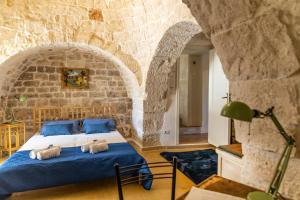 um quarto com uma cama numa parede de pedra em TRULLI MELOGINO with private beach volley camp em Ostuni
