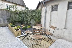 a patio with a table and chairs next to a building at Welcome Home in Linas