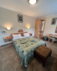 ein Schlafzimmer mit einem großen Bett und einem Tisch in der Unterkunft Гостиница ИЛЕК in Aqtöbe