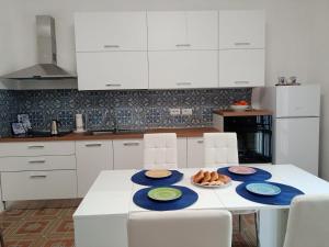 une cuisine avec une table et des assiettes de nourriture dans l'établissement Vila Tomas/Sona, à San Pietro in Bevagna