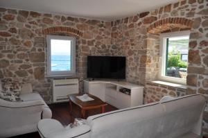 a living room with two couches and a flat screen tv at Dalmatian Villa Denis in Bol