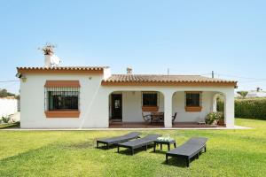 a small white house with two picnic tables in the yard at Casa Los Alamos in La Muela