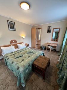 ein Schlafzimmer mit einem großen Bett und einem Tisch in der Unterkunft Гостиница ИЛЕК in Aqtöbe