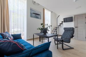 a living room with a blue couch and a table at DO DOMIS LOFT PALANGA in Palanga