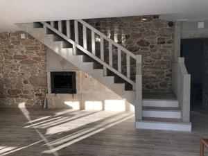- un escalier dans une chambre dotée d'un mur en pierre dans l'établissement Casa A Braña, à La Corogne