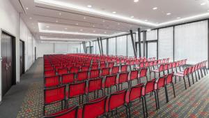 una habitación vacía con sillas rojas en un edificio en Holiday Inn Munich - Westpark, an IHG Hotel, en Múnich