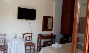 a room with a bed and a table and a television at Ενάλιον in Astypalaia