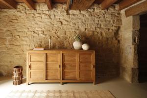 un armario de madera en una habitación con una pared de piedra en Casa ROBLA 