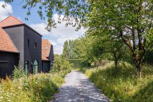 a dirt road next to a building and trees at Apartment L'O Reine in Sint-Pieters-Leeuw
