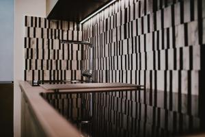 リュブリャナにあるKenti Residenceの白黒の壁のバスルーム(シンク2台付)