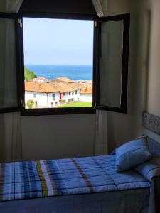 1 dormitorio con cama y ventana grande en Apartamento Tazones, en Tazones