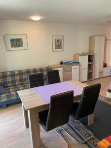 uma sala de estar com mesa e cadeiras em Private Wohnung Bunter Hund em Aalen