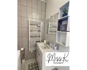 a white bathroom with a sink and a toilet at "Les Angelots" in Mâcon