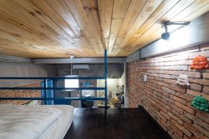 a room with a bed and a brick wall at Stay&Chill - S.1: Ancient studio nearby Bui Vien in Ho Chi Minh City