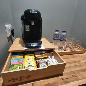 Beinn Mhor Lodge في إينفيرنيس: وجود آلة صنع القهوة على رأس صندوق على طاولة