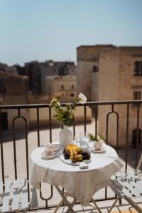 a table with a plate of food on a balcony at La Dimora dei WaLori in Bisceglie
