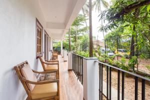 een balkon van een huis met stoelen en bomen bij Casa De Mor Villa with Pool in Anjuna +20 foto's