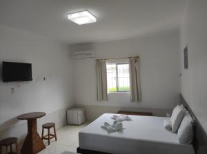 a white bedroom with a bed and a window at Pousada Sol Nascente in Piranhas +68 photos